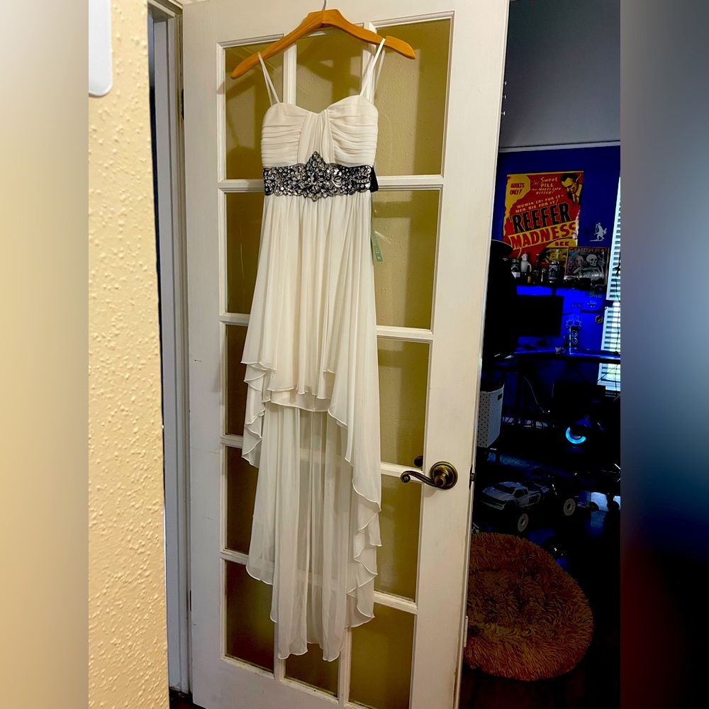 White strapless dress is asymmetrical with clear gems detail. Juniors size 3
